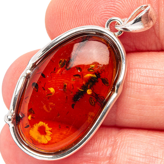 Amber pendant close-up: oval red-orange Baltic amber set in .925 sterling silver