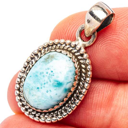 Sterling silver oval pendant with ornate bezel and light blue Larimar stone