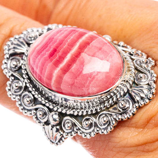 Sterling silver oval rhodochrosite cabochon ring on hand, size 7.5, detailed border filigree