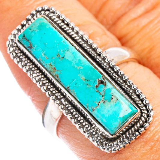 Turquoise rectangle sterling silver ring on finger, raised bezel with beaded edge