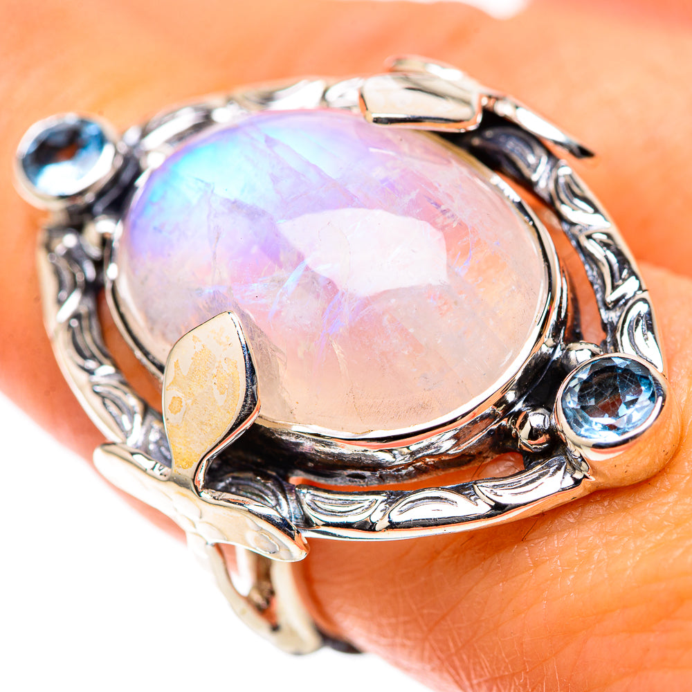 Silver oval moonstone ring with blue gemstone accents, ornate bezel setting