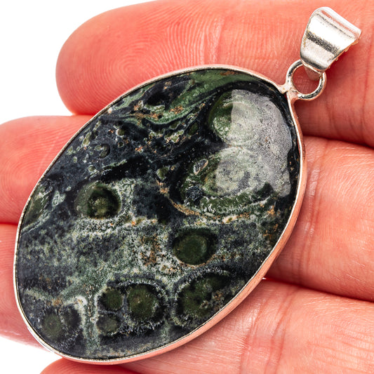 Silver-plated oval galaxy jasper pendant with top bail and dark blue green speckling.