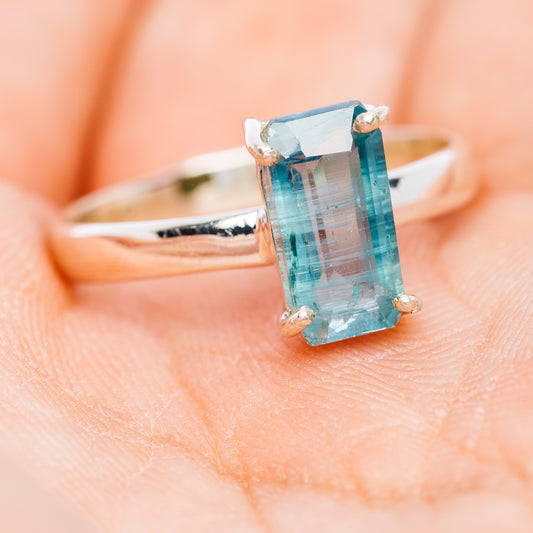 Faceted Paraiba kyanite ring with rectangular stone, silver bezel prongs, view from side