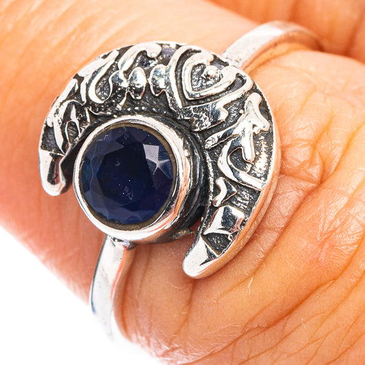 Sterling silver ring with oval blue gemstone, raised halo and carved moon design