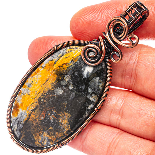Close-up teardrop jasper pendant with oxidized copper wire wrap and spiral bail