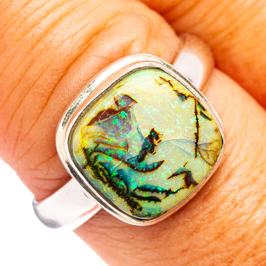Sterling silver oval opal ring with prong-set iridescent green and blue center