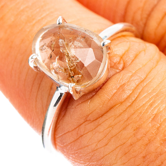 Sterling silver ring with round faceted clear cacoxenite gemstone, prong-set.