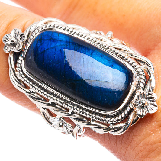 Sterling silver ring with oval blue labradorite-style gemstone and ornate raised border