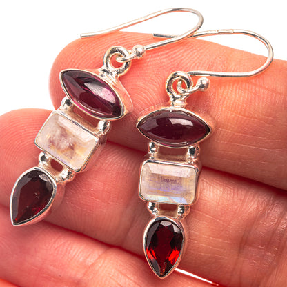 Sterling silver drop earrings with dark red oval stones, iridescent squares, and pink accents