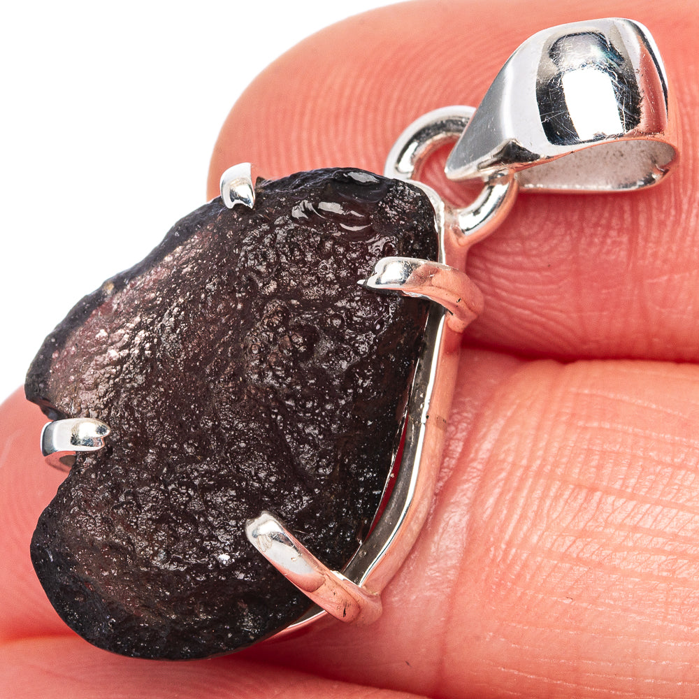 Sterling silver pendant with raw dark stone and open bail, faceted bezel frame