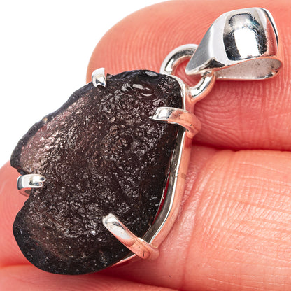 Sterling silver pendant with raw dark stone and open bail, faceted bezel frame