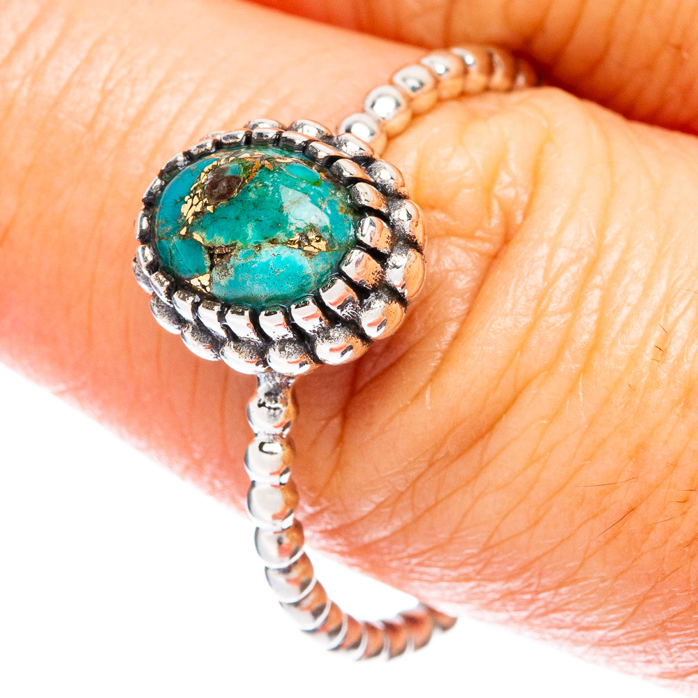 Turquoise cabochon dainty silver ring with ornate bezel and beaded border, on finger