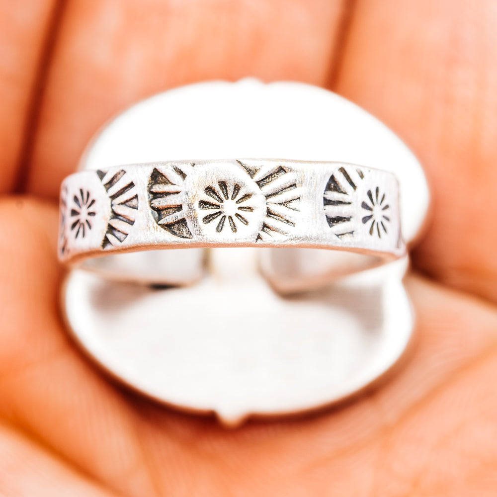Sterling silver ring band with decorative stamped motifs along the side