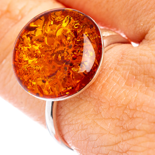 Amber cabochon ring with warm honey-orange stone in a silver bezel setting