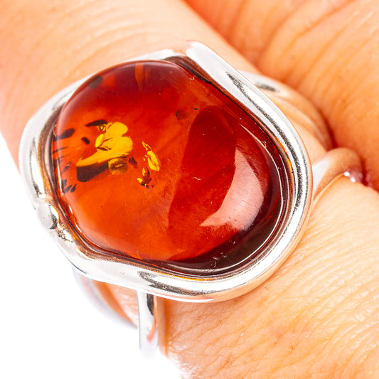 Oval amber cabochon ring in .925 sterling silver, red-orange with yellow inclusions