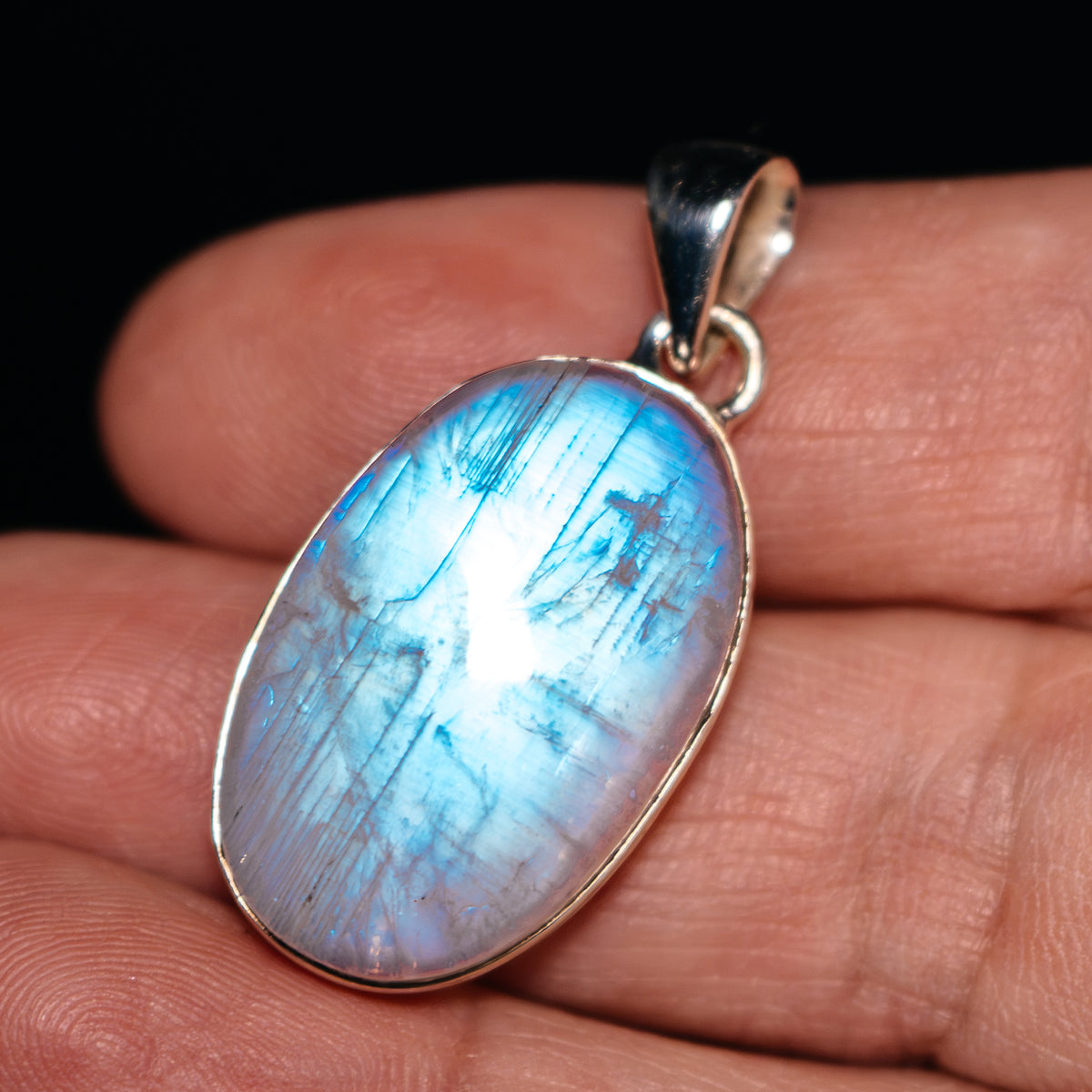 Oval rainbow moonstone pendant with .925 sterling silver bezel, luminous blue flash
