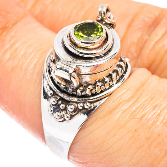Sterling silver ring with round peridot-green gemstone and engraved swirl filigree.