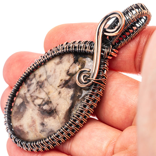 Oxidized copper wire-wrap pendant with teardrop stone centerpiece, detailed close-up