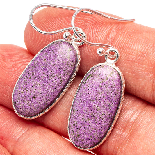 Sterling silver stichtite earrings with oval purple stone dangles on fingers