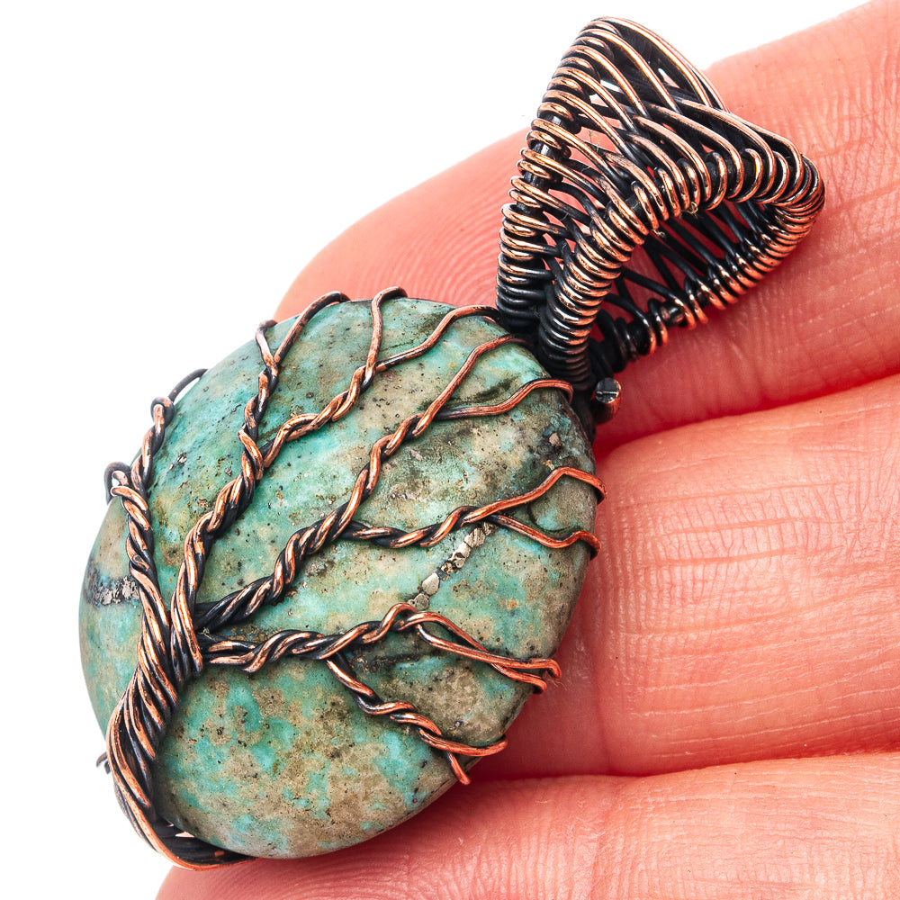 Turquoise oval pendant close-up with oxidized copper wire tree-of-life detail