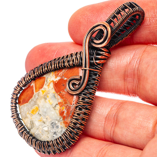 Red jasper teardrop wire-wrap pendant detail on oxidized copper coil and bail