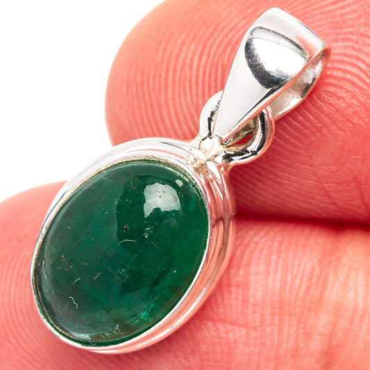 Sterling silver emerald pendant with oval bezel-set green gemstone, close-up bail