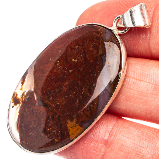 Oval red jasper pendant close-up with silver-plated bezel and bail
