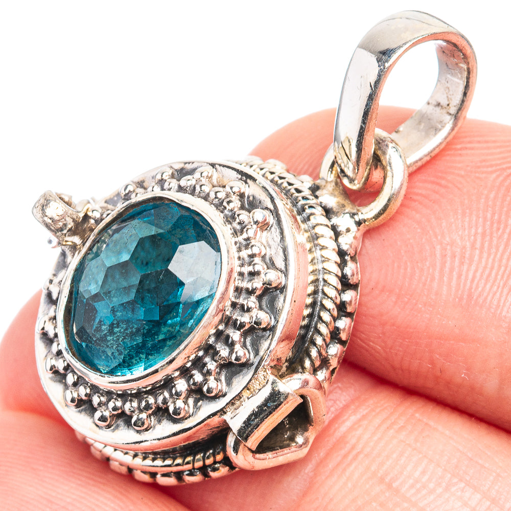 Sterling silver pendant with oval faceted teal-blue gemstone, ornate bezel and loop