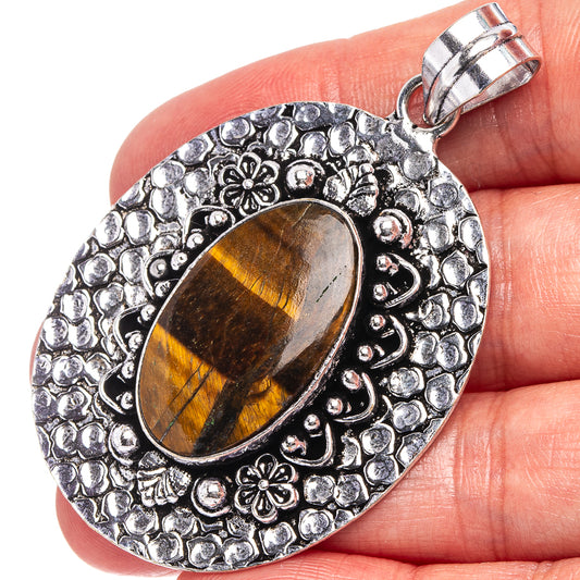 Silver-toned tiger's eye oval pendant with ornate pebble setting and loop bail