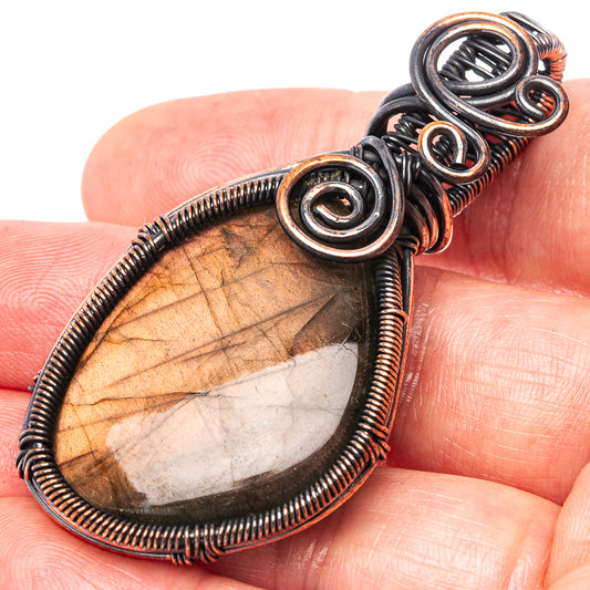 Oxidized copper wire wrap teardrop pendant with iridescent labradorite stone, close-up