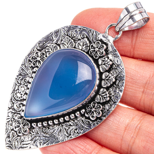 Teardrop blue chalcedony pendant in German silver with floral etched border