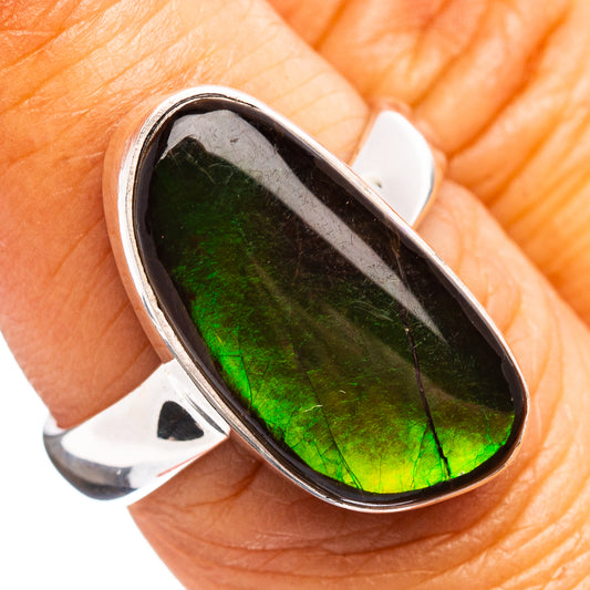 Oval sterling silver ring with iridescent green ammolite stone, bezel-set.
