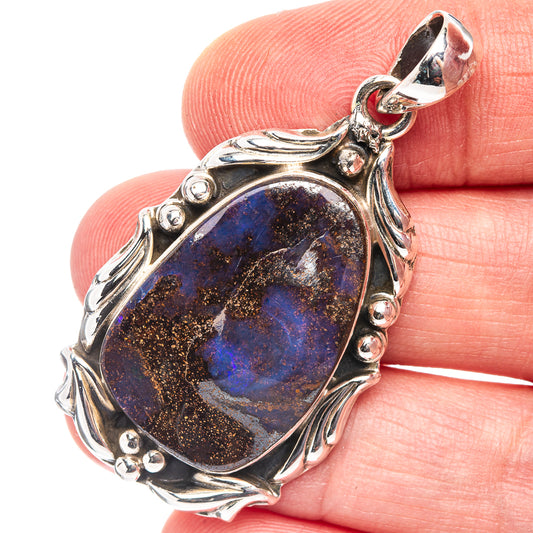 Sterling silver boulder opal pendant with dark blue oval stone and ornate scroll setting