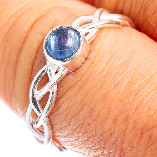 Sterling silver kyanite cabochon ring on finger, twisted band with round blue gemstone top