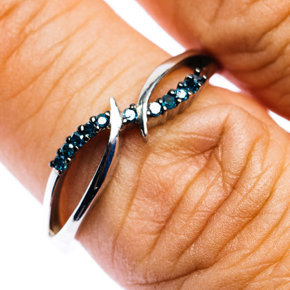 Blue diamond sterling silver ring with split open band on a finger