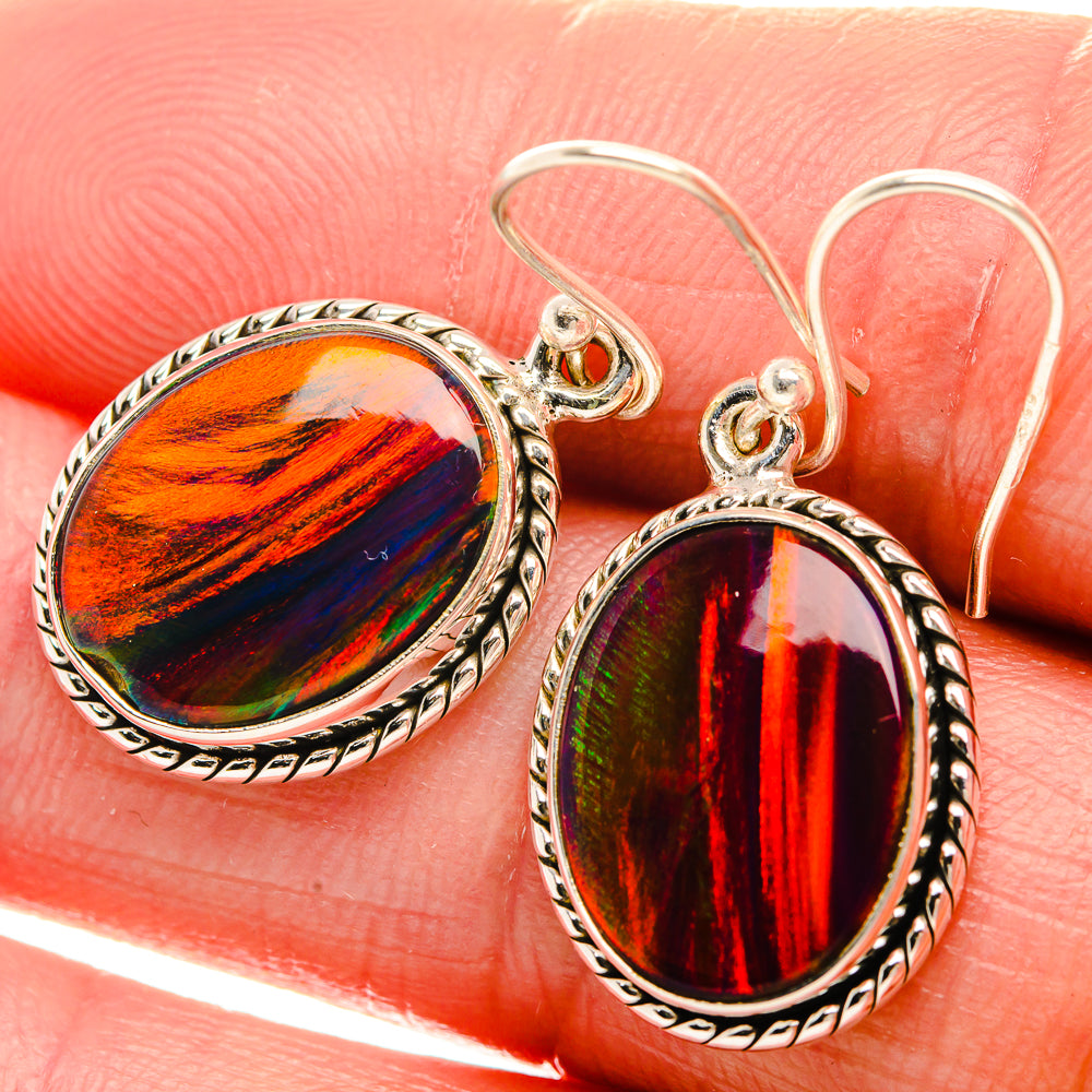 Sterling silver oval opal drop earrings with ornate bezel and red-green/orange-blue stones