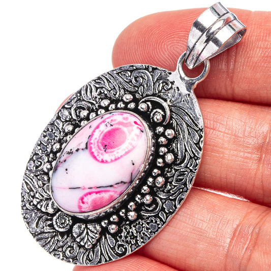 Silver-tone oval opal pendant with pink dendritic stone, ornate filigree frame