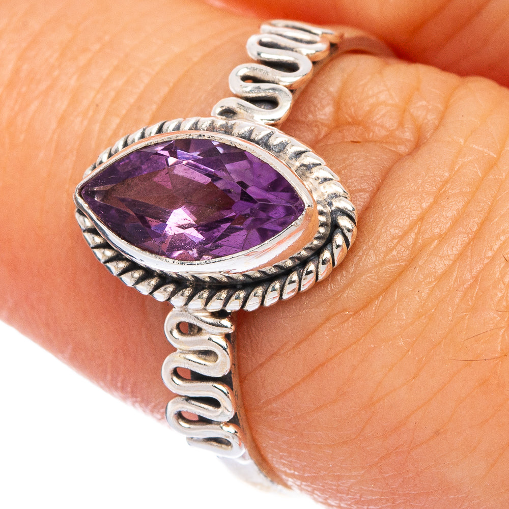 Sterling silver amethyst ring with oval faceted purple gemstone and raised scroll band