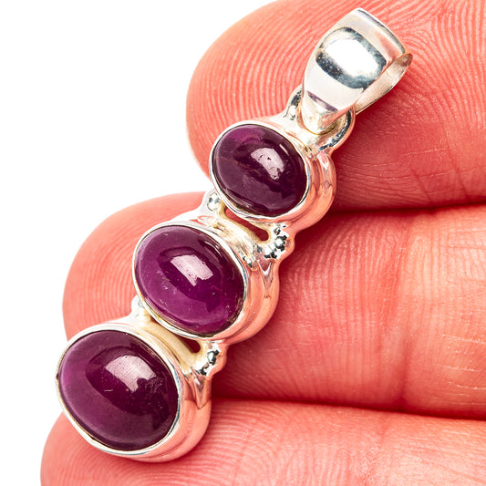 Sterling silver three-stone oval ruby pendant with three deep purple cabochon gems