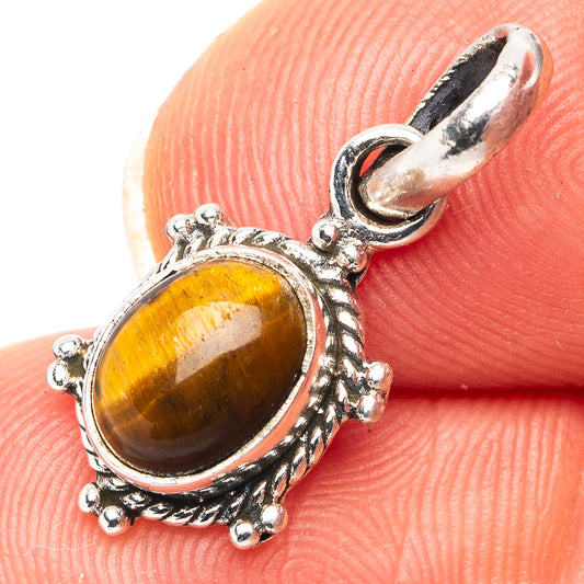 Tiger's eye pendant with oval amber cabochon in ornate .925 silver bezel