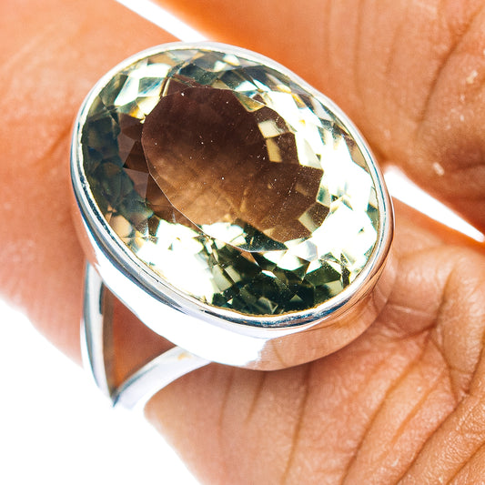 Oval green amethyst faceted ring set in polished sterling silver band, close-up top view