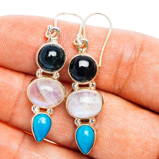 Sterling silver dangle earrings with black round stones, pink discs, and blue teardrops