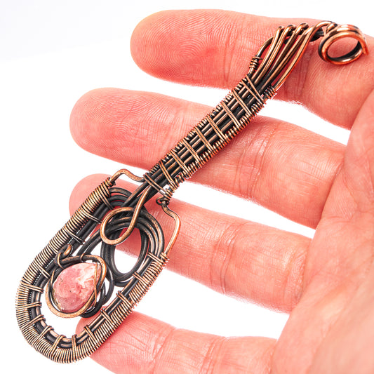 Oxidized copper wire-wrap pendant detail with pink oval stone and loop bail