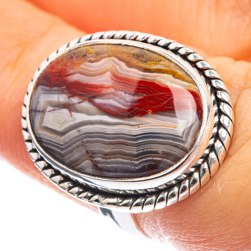 Oval crazy lace agate ring with red, white, and gray striped stone in silver bezel