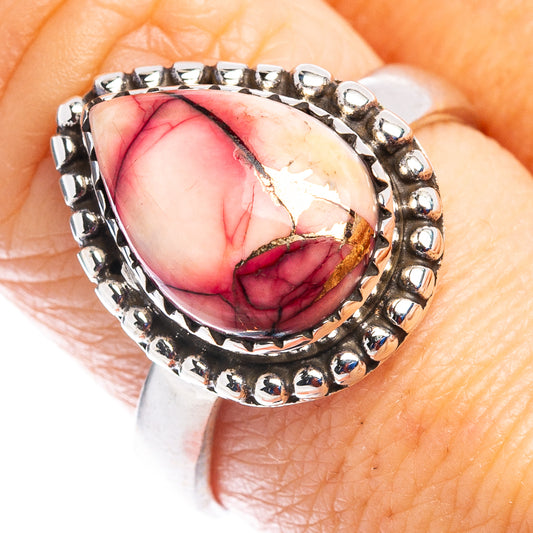 Sterling silver ring with oval red-pink stone and beaded halo setting