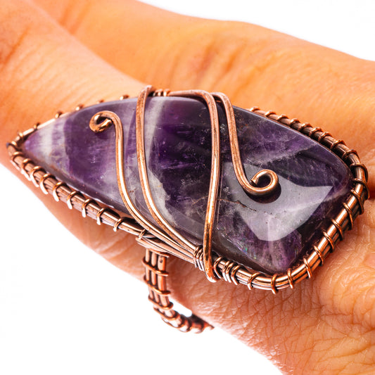 Oxidized copper amethyst ring with oval purple gemstone and swirling wire filigree