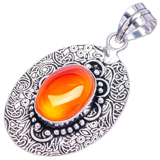 Silver teardrop pendant with orange opal cabochon and detailed filigree frame