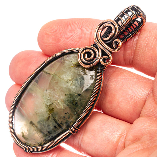 Oxidized copper wire-wrapped prehnite teardrop pendant with spiral bezel detail