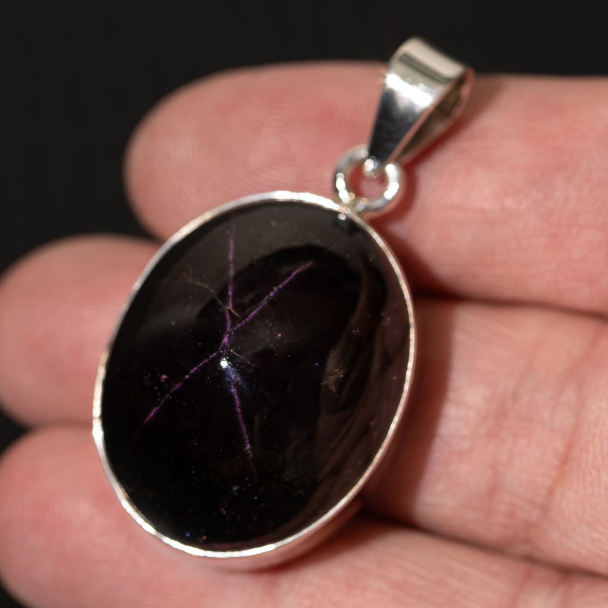 Star-shaped garnet pendant with round dark gemstone and .925 sterling silver bezel