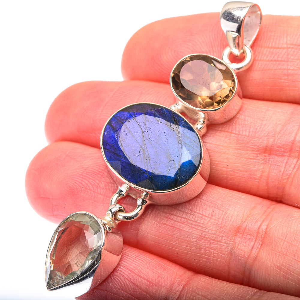Sterling silver pendant with oval blue, smoky, and light green gemstones, bail visible